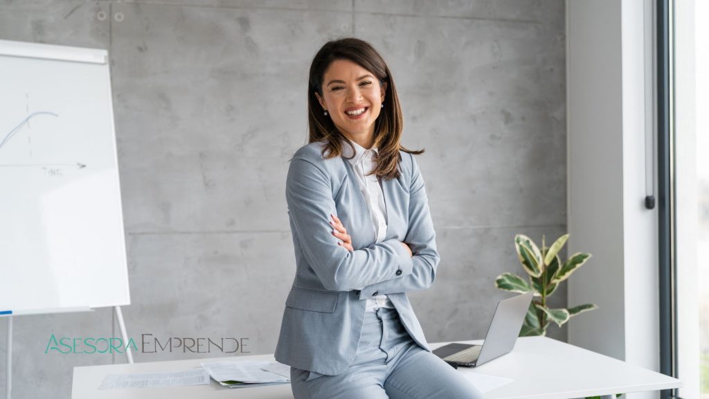 Asesora profesional sonriendo en oficina moderna con portátil, imagen corporativa de Asesoraemprende para artículo sobre Bono Autónomo Galicia 2026.
